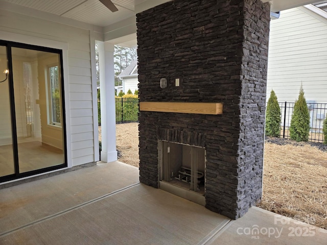 view of patio featuring ceiling fan and an outdoor stone fireplace