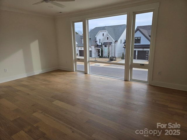 empty room with hardwood / wood-style flooring, ornamental molding, and ceiling fan