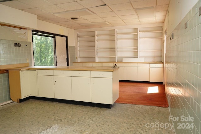 kitchen featuring tile walls and white cabinets