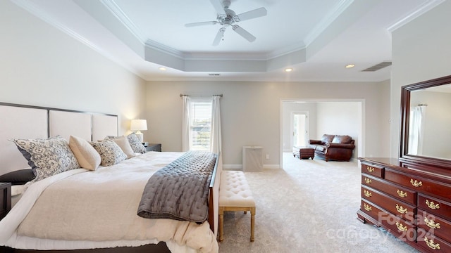 bedroom featuring a raised ceiling, ornamental molding, ceiling fan, and light colored carpet