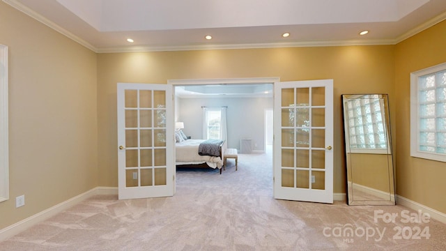 interior space featuring a healthy amount of sunlight, ornamental molding, light carpet, and french doors