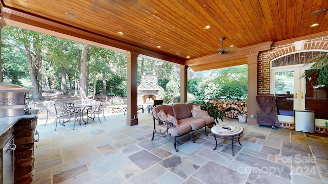 view of patio with an outdoor living space with a fireplace