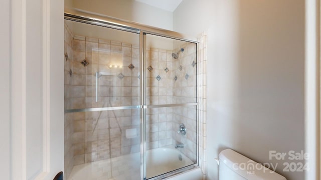 bathroom with enclosed tub / shower combo and toilet