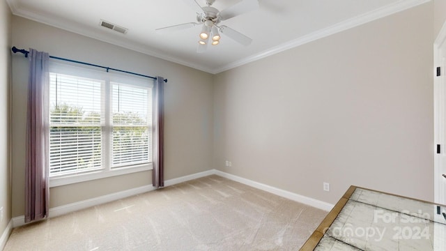 carpeted spare room with ceiling fan and ornamental molding