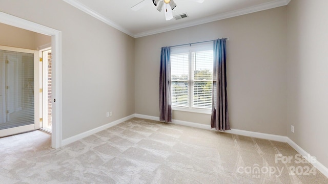 spare room featuring light carpet, ceiling fan, and ornamental molding