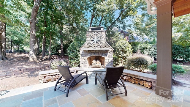 view of patio featuring an outdoor stone fireplace