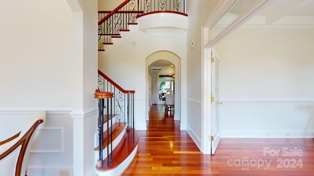 foyer featuring ornamental molding, hardwood / wood-style floors, and a high ceiling