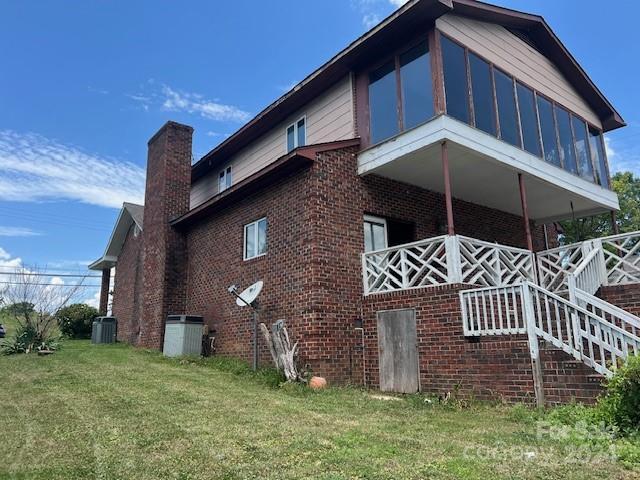 view of home's exterior with a lawn and a sunroom