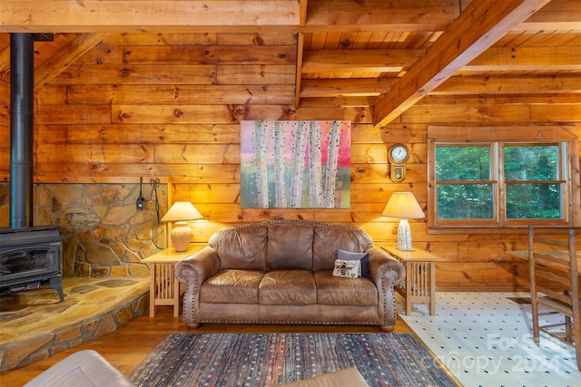 living room with wood ceiling, a wood stove, wood-type flooring, and beamed ceiling