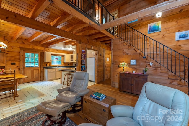 living room featuring beam ceiling, wood ceiling, and wood walls