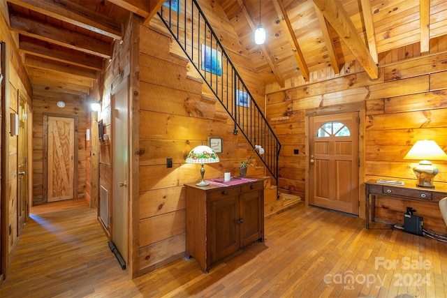 foyer entrance featuring wooden ceiling, wood-type flooring, and wooden walls