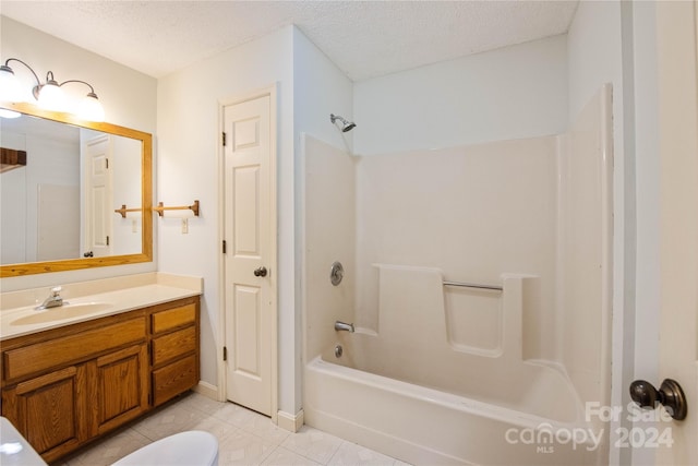 bathroom with tile patterned flooring, vanity, a textured ceiling, and washtub / shower combination