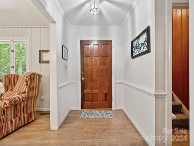 entryway with light hardwood / wood-style floors and ornamental molding