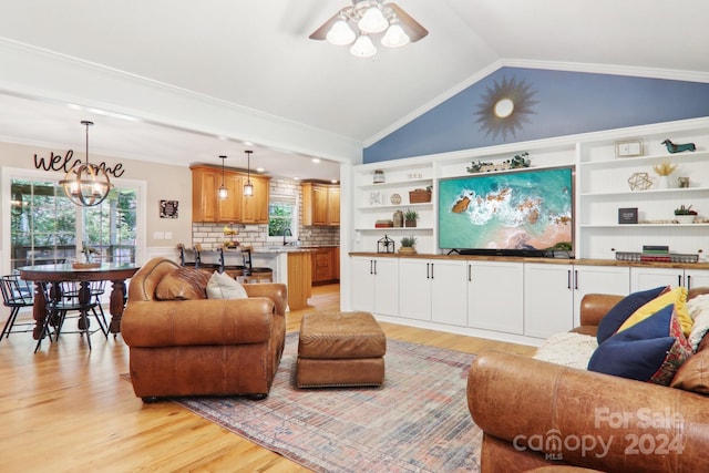 living room featuring crown molding, ceiling fan with notable chandelier, and lofted ceiling