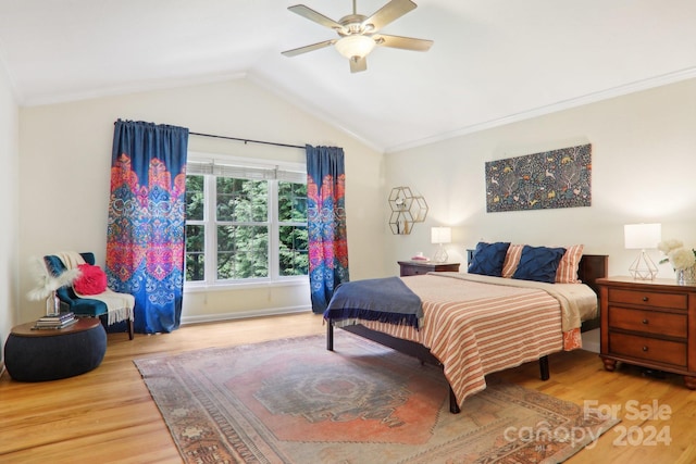 bedroom with ceiling fan, crown molding, light hardwood / wood-style floors, and vaulted ceiling