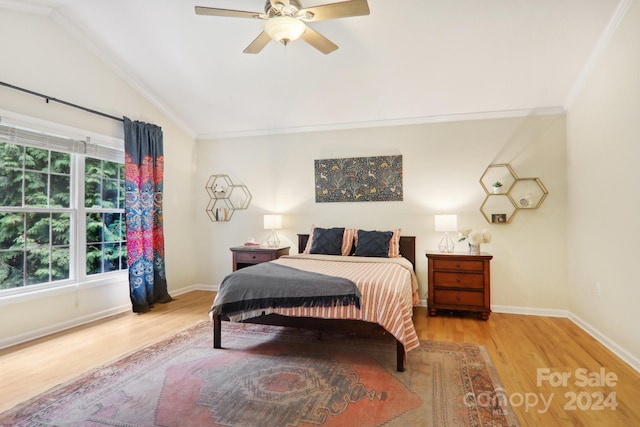 bedroom featuring light wood-type flooring, vaulted ceiling, ceiling fan, and crown molding