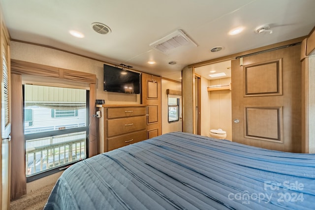 bedroom with ensuite bathroom and carpet floors