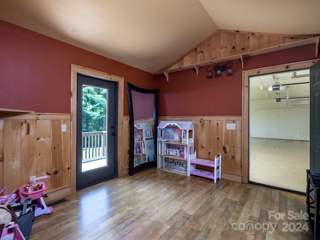 doorway with wood-type flooring and lofted ceiling