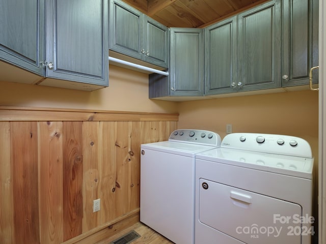 washroom with cabinets, light hardwood / wood-style flooring, and washing machine and clothes dryer