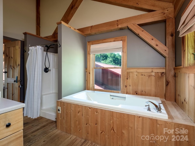 bathroom with vaulted ceiling, independent shower and bath, and hardwood / wood-style floors