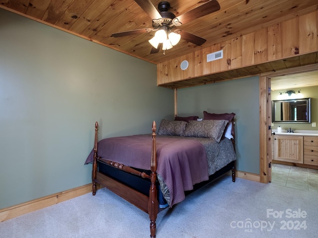 carpeted bedroom with ceiling fan, sink, ensuite bath, and wooden ceiling