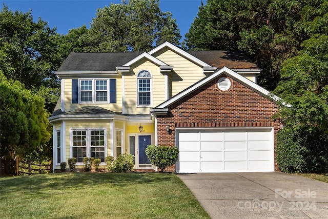 view of property featuring a garage and a front lawn