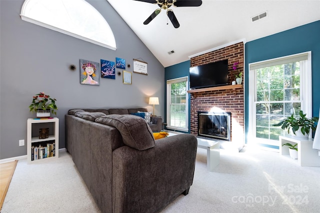 carpeted living room featuring a fireplace, high vaulted ceiling, and ceiling fan