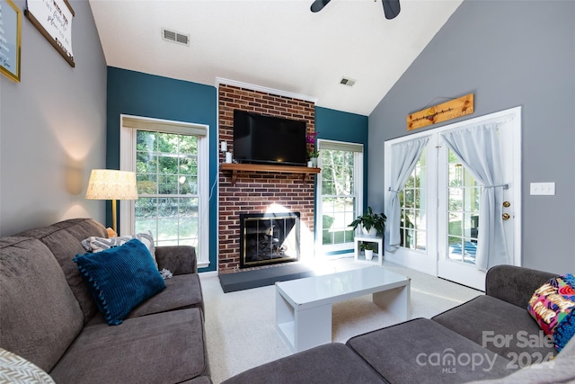 carpeted living room featuring a brick fireplace, ceiling fan, and vaulted ceiling