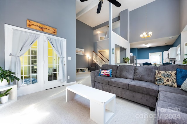 living room featuring a towering ceiling and ceiling fan with notable chandelier