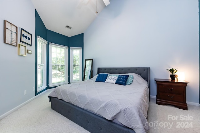 bedroom featuring light carpet, vaulted ceiling, and ceiling fan