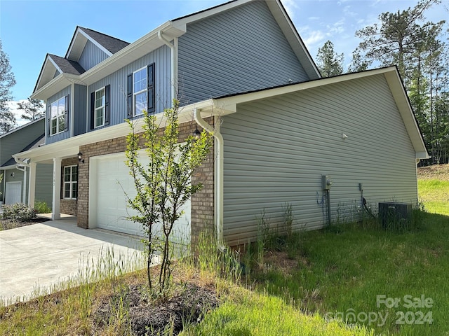 view of property exterior with a garage and central air condition unit