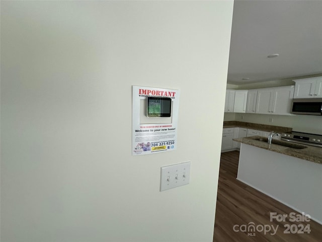 kitchen with sink, dark hardwood / wood-style flooring, white cabinets, and stainless steel appliances