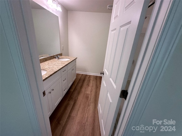 bathroom featuring double vanity and wood-type flooring