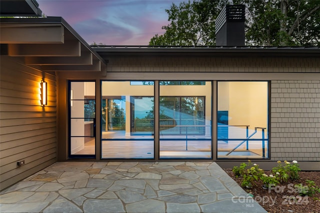 exterior entry at dusk with a patio