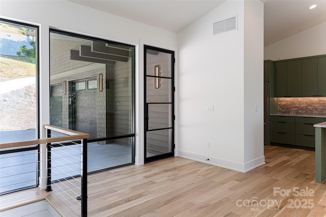 spare room featuring lofted ceiling, recessed lighting, visible vents, baseboards, and light wood finished floors