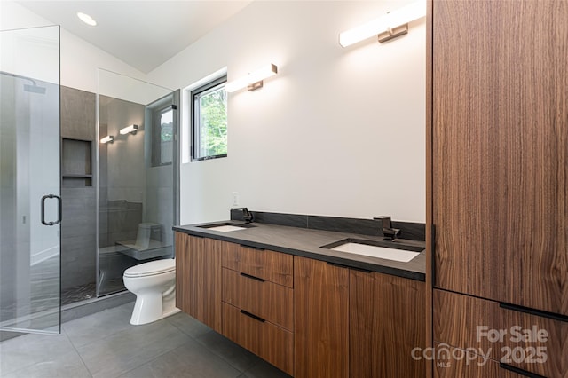 bathroom featuring double vanity, toilet, a sink, and tile patterned floors