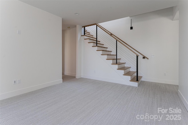 stairway featuring carpet floors and baseboards