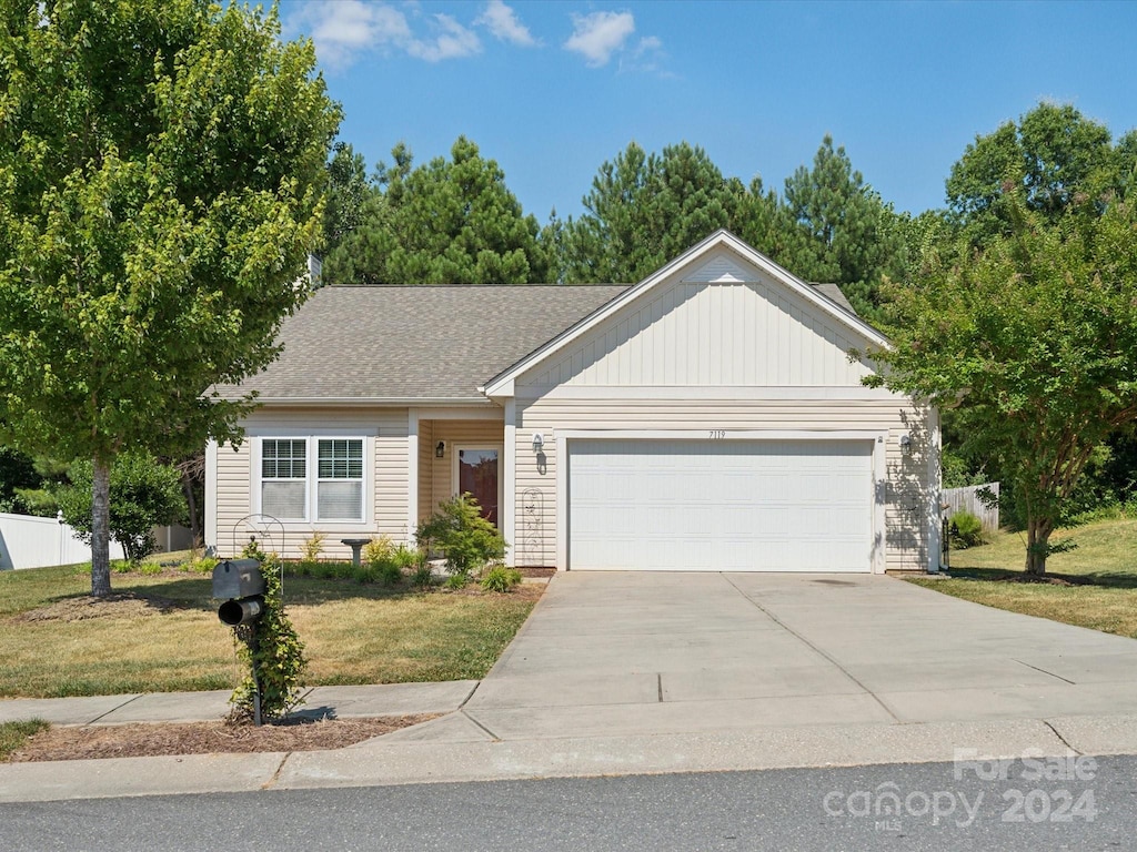 single story home featuring a front lawn and a garage