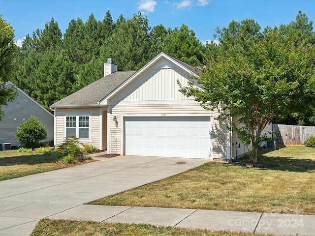 view of front facade featuring central AC unit, a garage, and a front lawn