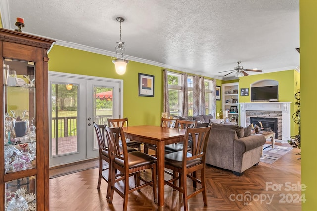 dining room featuring built in shelves, ceiling fan, french doors, dark parquet floors, and a fireplace