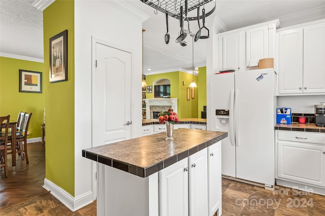 kitchen with white cabinetry, white fridge with ice dispenser, and a kitchen island