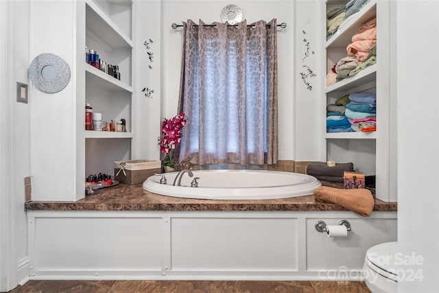 bathroom with a washtub and toilet