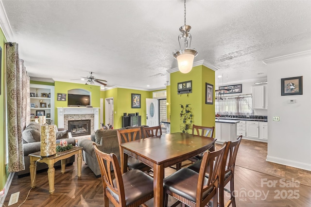 3951 Springs Rd, Conover, NC 28613 - dining room featuring a ceiling fan, a glass covered fireplace, plenty of natural light, baseboards, and a textured ceiling