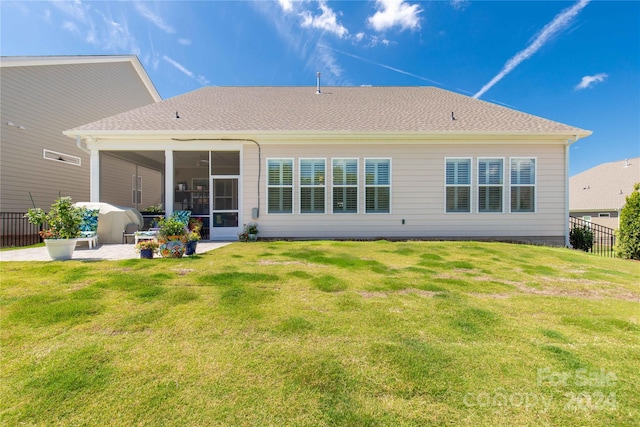 back of property with a patio, a yard, and a sunroom