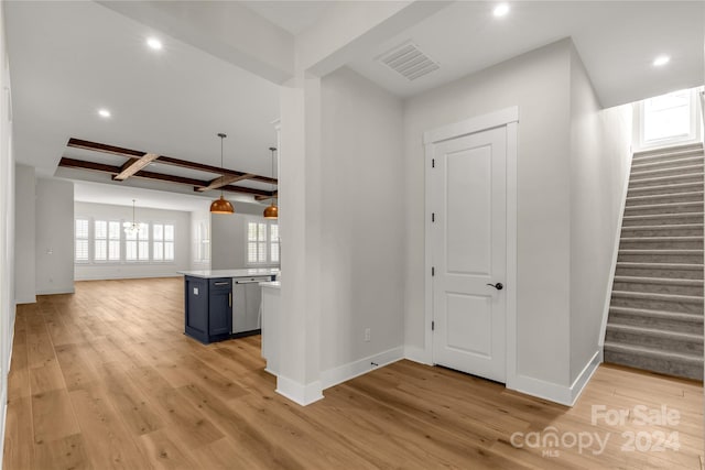 hall with light hardwood / wood-style flooring, beam ceiling, a chandelier, and coffered ceiling