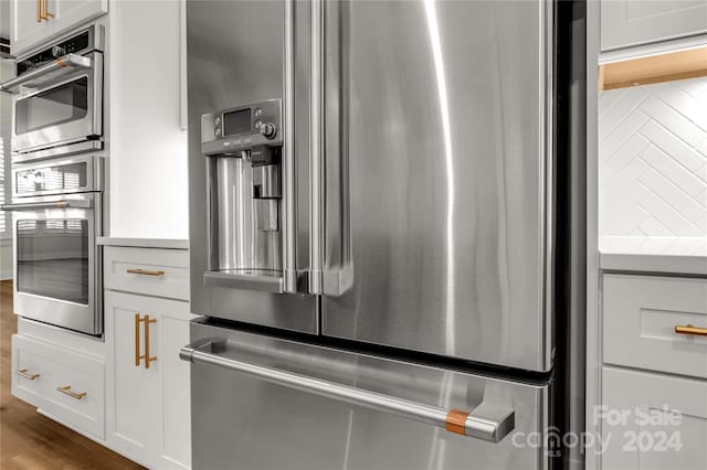 room details featuring appliances with stainless steel finishes and white cabinetry