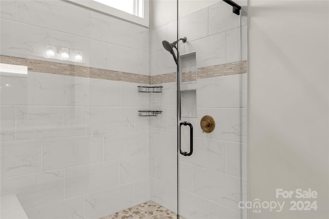 bathroom featuring a shower with door