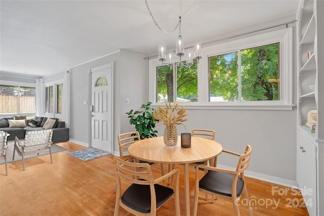 dining space with light hardwood / wood-style flooring and a notable chandelier