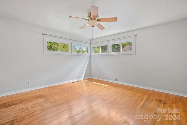 empty room with ceiling fan, light hardwood / wood-style flooring, and plenty of natural light