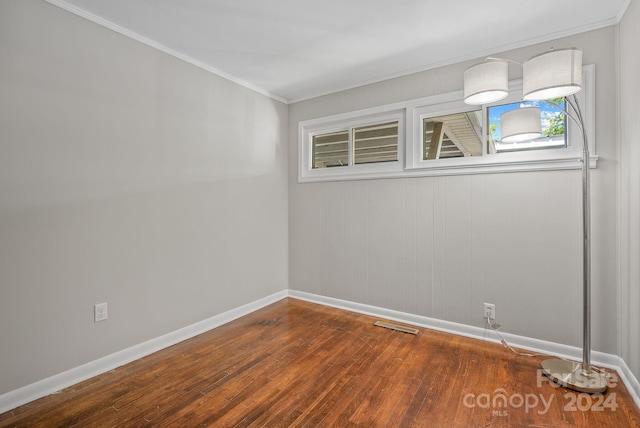 spare room with ornamental molding and hardwood / wood-style flooring